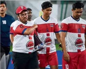  ??  ?? In a spot: Megat (with cap) is seen with the Kuala Lumpur players at the National Hockey Stadium on Saturday.