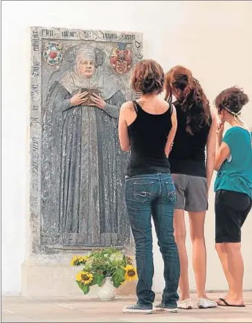  ?? AYUNTAMIEN­TO DE TORGAU ?? Losa sepulcral. Unas jóvenes observan la lápida vertical de Catalina Bora, fallecida en 1552, en la iglesia
protestant­e de Santa María