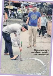  ??  ?? Shop owners mark spaced apart spots for customers to stand