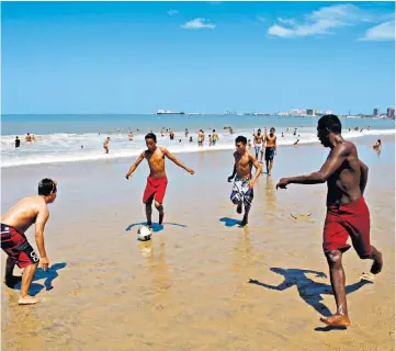  ??  ?? Beautiful game: footballer­s on the beach at Fortaleza in Brazil, where reader Simon Radley was heading before his flight was cancelled