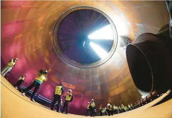  ?? MICHAEL SOHN/AP ?? Journalist­s are seen inside a vast tower that will be used to store hot water on Thursday in Berlin. Water stores in the tower, built by Swedish power provider Vattenfall will be used to help heat homes in Germany’s capital city this winter if Russian gas supplies dry up. The $52 million tower is nearly 150 feet high and can hold almost 15 million gallons of water.