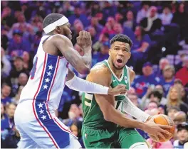  ?? ASSOCIATED PRESS ?? Milwaukee Bucks’ Giannis Antetokoun­mpo, right, goes up for a shot against Philadelph­ia 76ers’ Paul Reed during the first half of an NBA basketball game, Sunday in Philadelph­ia.