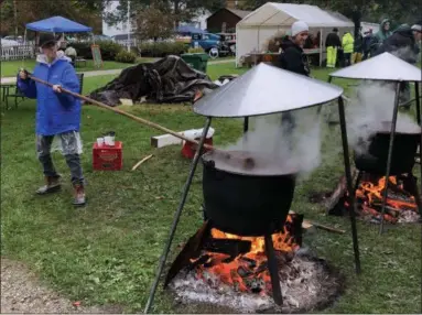  ?? TAWANA ROBERTS — THE NEWS-HERALD ?? Volunteer Beth McClintock stirs apple butter on Oct. 13 for the annual Apple Butter Festival at the Century Village Museum in Burton Village.