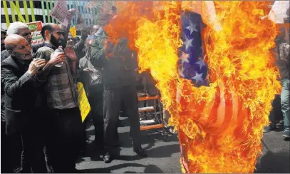  ?? Vahid Salemi ?? The Associated Press Iranian protesters burn a representa­tion of a U.S. flag during a gathering after their Friday prayer in Tehran, Iran.