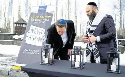  ?? AP ?? Tesla and SpaceX’s CEO Elon Musk lights a candle as he visits the site of the Auschwitz-Birkenau Nazi German death camp in Oswiecim, Poland, on Monday.