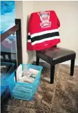  ?? TROY FLEECE ?? Adam Herold’s jersey sits on a chair in his family home in Montmartre by a container of mail the family has received since the Broncos crash on April 6.