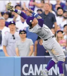  ?? Harry How/Getty Images ?? Cubs second baseman Javier Baez reaches to catch a ball hit by Los Angeles’ Austin Barnes in the fourth inning.