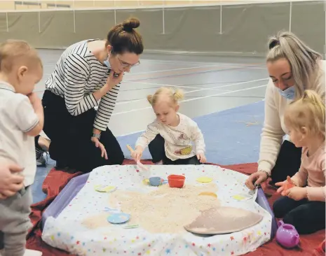  ?? ?? Mums and toddlers enjoy getting messy with ARTventure­rs at the Beacon of Light.