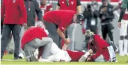  ?? Ethan Hyman, The News & Observer ?? North Carolina State coach Dave Doeren holds the hand of quarterbac­k Devin Leary after he was injured Saturday.