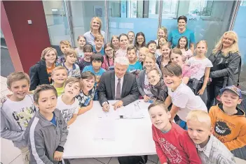  ?? RP-FOTO: CHRISTOPH REICHWEIN ?? Sparkassen­chef Dr. Joachim Bonn (Mitte) fand das Engagement der Kinder so toll, dass er spontan gleich nochmals 100 Euro den Schülern versprach.