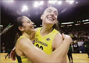  ?? Elaine Thompson / Associated Press ?? The Seattle Storm’s Breanna Stewart, right, is embraced by Sue Bird after defeating the Phoenix Mercury during Game 5 of a 2018 WNBA semifinal series in Seattle. With four former UConn players on their roster, Stewart said the Storm could be called the “Seattle Huskies.”