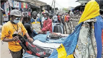  ?? Picture: REUTERS / THOMAS MUKOYA ?? TOUGH MARKET: Customers select imported second-hand clothes amid the coronaviru­s disease outbreak at the Gikomba market in Nairobi, Kenya.