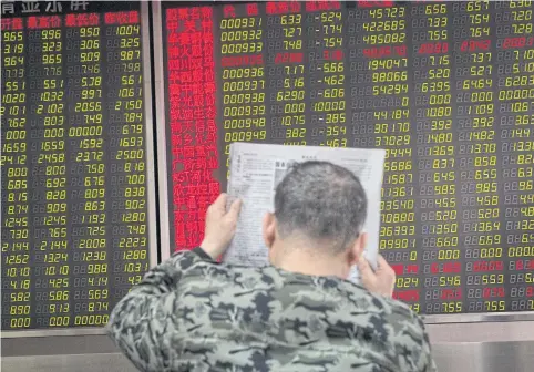  ?? EPA-EFE ?? A man reads stock prices at a securities brokerage in Beijing as China’s market dropped following the new US policy imposing tariffs on Chinese goods.