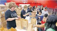  ?? [THE OKLAHOMAN ARCHIVES] ?? OKC Faith Church vlunteer Robin Totten hands bags of school supplies to children at the 2009 Feeding the 5,000 and More back-to-school event at the church, 800 S Portland.