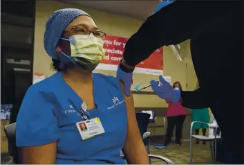  ?? KARL MONDON — BAY AREA NEWS GROUP ?? With her colleagues cheering her on, Maria Reyes, a registered nurse in the ICU at Kaiser Permanente San Jose, is the first person to get vaccinated at the facility for COVID-19 on Dec. 18.