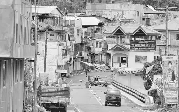  ??  ?? A view of the Maute group stronghold with an ISIS flag in Marawi City in southern Philippine­s. — Reuters photo