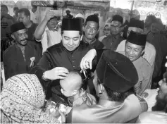  ??  ?? Nazifuddin helps one of the children with his haircut.