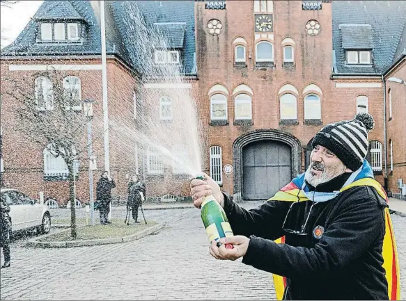  ??  ?? Un simpatizan­te del expresiden­t Carles Puigdemont celebrando ayer la decisión de la justicia alemana ante la prisión de Neumünster