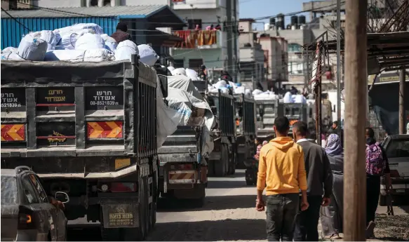  ?? AFP ?? Lorries carrying humanitari­an aid make their way along a street in Rafah in the southern Gaza Strip near the border with Egypt yesterday