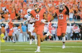  ?? BRIAN BAHR/GETTY ?? Oklahoma State’s Bryson Green (9) scores the winning touchdown after breaking several tackles against Texas on Saturday in Stillwater, Oklahoma.