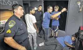  ?? LANNIS WATERS / THE PALM BEACH POST ?? Boynton Beach Police officers and Congress Middle School Students try to solve clues in an escape room in West Palm Beach on Friday as part of the Boys in Blue mentoring program.