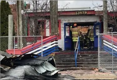  ?? MITCH HOTTS — THE MACOMB DAILY ?? Investigat­ors from the Sterling Heights Fire Department examine the rubble after a fire destroyed the closed Joe’s Crab Shack early Wednesday.