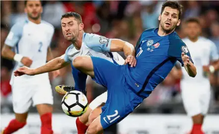  ??  ?? England defender Gary Cahill (centre) pushes aside Slovakia striker Michal Duris during their Group F World Cup qualifying match at Wembley. England won 2-1. — Reuters Out of my way: