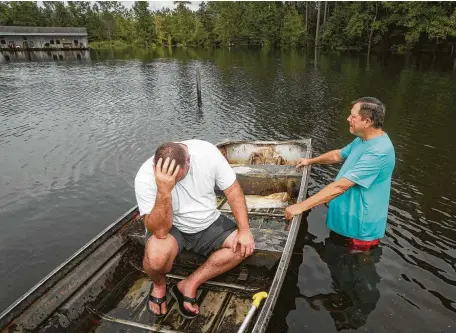  ?? Jon Shapley / Staff photograph­er ?? Stephen Gilbert, left, and his father-in-law reflect in front of their flooded property Friday in the Mauricevil­le area. “I’m on my third house,” said Gilbert, who lives behind his father-in-law. “I wouldn’t go anywhere else in the world. All we have is family anyway.”