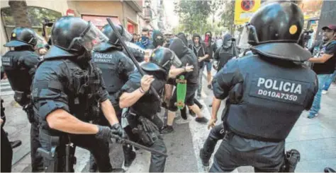  ?? EFE ?? Agentes de los Mossos cargan contra manifestan­tes en una concentrac­ión en Barcelona