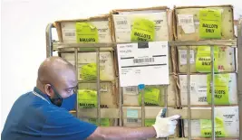  ?? WILFREDOLE­E APPHOTO/ ?? AMiami-Dade County ElectionsD­epartment employee loads a cart of vote-by-mail ballots into a truck for transport to a localU.S. Postal Service office, Oct. 1 inDoral.