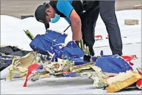  ?? [TATAN SYUFLANA/ THE ASSOCIATED PRESS] ?? An investigat­or of Indonesian National Transporta­tion Safety Committee inspects parts of Sriwijaya Air Flight 182 that crashed in the waters off Java Island, on Sunday at Tanjung Priok Port in Jakarta, Indonesia.