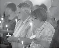  ?? Andrew Vaughan/The Canadian Press via AP ?? ■ Residents attend a candleligh­t vigil Friday at St. John the Evangelist Anglican Church in Fredericto­n, New Brunswick. Two city police officers were among four people who died in a shooting in a residentia­l area on the city’s north side.