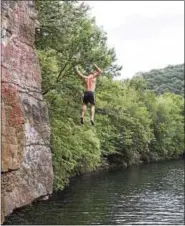  ??  ?? Jumping off the Rock into the Schuylkill River in Tilden Township on Sunday.