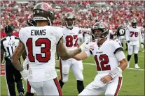  ?? MARK LOMOGLIO — THE ASSOCIATED PRESS ?? Buccaneers quarterbac­k Tom Brady, right, celebrates with wide receiver Mike Evans after Evans caught a three-yard touchdown pass during the first half of a game against the Atlanta Falcons Sunday in Tampa.