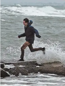  ?? STAFF PHOTOS, ABOVE AND BELOW, BY MATT STONE; FAR LEFT, BY CHRIS CHRISTO; HERALD FILE PHOTO, LEFT ?? MORE MADNESS: People, above and below, check out the waves crashing near the Scituate Lighthouse yesterday ahead of the latest storm.