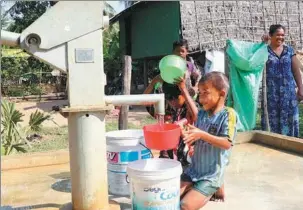  ?? ZHANG ZHAO / XINHUA ?? Children fetch water from a new well constructe­d under the Phase II of China-aided rural water supply and road projects in Kampong Speu province of Cambodia.