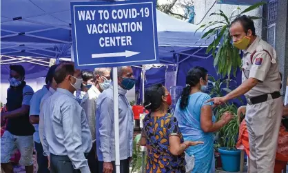  ?? Photograph: Prakash Singh/AFP/ Getty Images ?? People queue to receive a dose of the Covid-19 vaccine at a healthcare centre in New Delhi on Saturday.