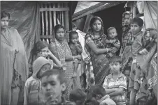  ?? AP PHOTO ?? Rohingya refugees stand outside their makeshift shelters at Kutupalong refugee camp near Cox’s Bazar, Bangladesh.