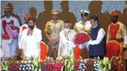  ?? — RAJESH JADHAV ?? Maharashtr­a CM Eknath Shinde looks on as deputy chief minister Devendra Fadnavis is presented a bouquet by governor Bhagat Singh Koshyari during the swearing in ceremony at Raj Bhavan in Mumbai on Thursday.