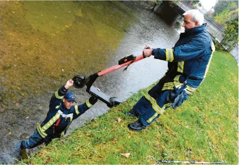  ?? Foto: Silvio Wyszengrad ?? Kein Einzelfall: Die Augsburger Feuerwehr musste bereits mehrfach ausrücken, um E-Roller aus Kanälen zu holen. Anselm Brieger (links) und Peter Fassold bergen hier ein Fahrzeug aus dem Proviantba­ch bei der MAN-Brücke an der Ecke Hans-Böckler-Straße und Berliner Allee.