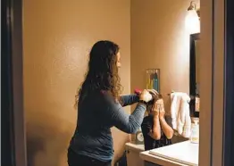  ?? ARIANA DREHSLER PHOTOS ?? Andrea Morales brushes her son Reece’s hair before taking him and his brother Keiran to the first day of in-person school in Tierrasant­a on Monday.