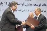  ?? — Reuters ?? Patrick Pouyanne (L), Chairman and CEO of Total, shakes hands with Ezzatollah Akbari, Managing Director of Petropars Group, after signing an offshore gas field agreement in Tehran, on Monday.