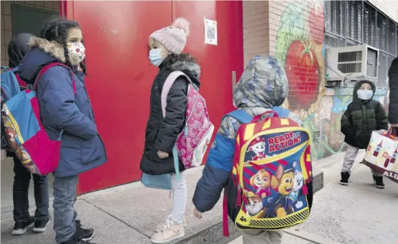 ?? (Photo: AP) ?? Students enter PS 134 Henrietta Szold Elementary School, in New York, yesterday. Public schools reopened for in-school learning after being closed since mid-november. Closures have been blamed for low grades as some students have challenges dealing with distance learning or do not attend classes.