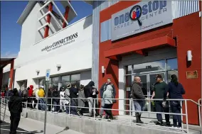  ?? JOHN LOCHER — THE ASSOCIATED PRESS FILE ?? People wait in line for help with unemployme­nt benefits at the One-Stop Career Center in Las Vegas on March 17.