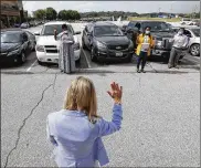  ?? AP ?? People take the Oath of Allegiance from deputy clerk Penny Luthens, center, during a drive-thru naturaliza­tion ceremony on June 26 in Des Moines, Iowa.