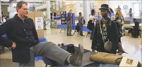  ?? SUBMITTED PHOTO ?? Civil War re-enactor Robert Bowser, left, shows visitors to the History, Industry, Technology and Science Expo what sort of shoes Civil War soldiers wore.