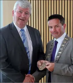  ??  ?? Wexford County Council’s new chairman John Hegarty (right) receives the chain of office from outgoing chairman Paddy Kavanagh. LEFT: Cllr Hegarty is congratula­ted by his wife Karina.