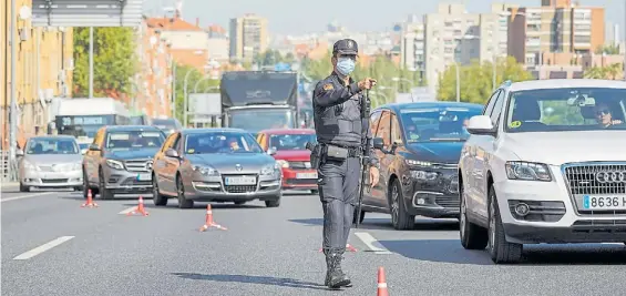  ??  ?? Controles. Efectivos de la policía nacional vigilan el cumplimien­to de las restriccio­nes a la movilidad impuestas por el Gobierno.BLOOMBERG