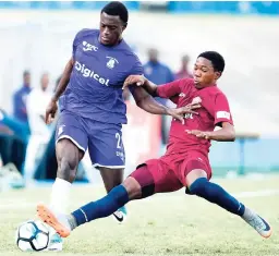  ?? X ?? Jahmal Pusey (left) of Kingston College is tackled by St Andrew Technical’s Jenuin Pinnock during their ISSA/Digicel Manning Cup semi-final match at the National Stadium yesterday. KC won 2-1.