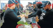  ?? Picture: ALAN EASON ?? HELPING HANDS: Daily Dispatch volunteers pack nutritious meals in last year's Stop Hunger Now campaign at Hemingways Mall. This year's event takes place at the mall on Saturday. Businesses and individual­s have until noon today to sign up to do their...